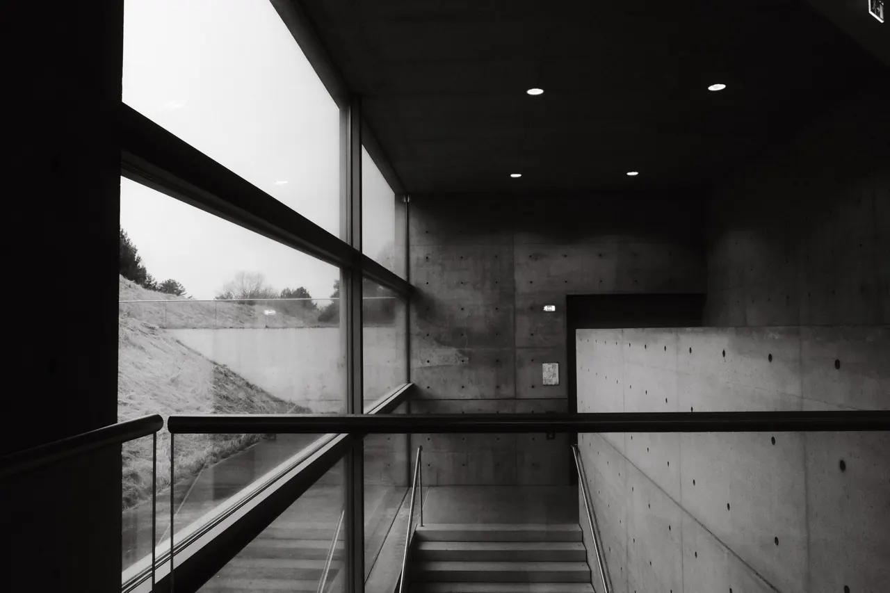 Interior en blanco y negro con escalera y ventanal