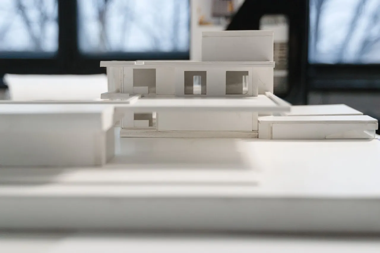 Maqueta de una vivienda sobre la mesa del estudio, con luz natural