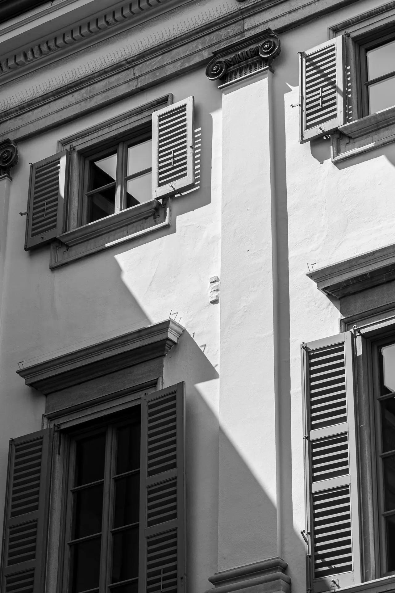 Fachada de edificio antiguo con balcones y contraventanas