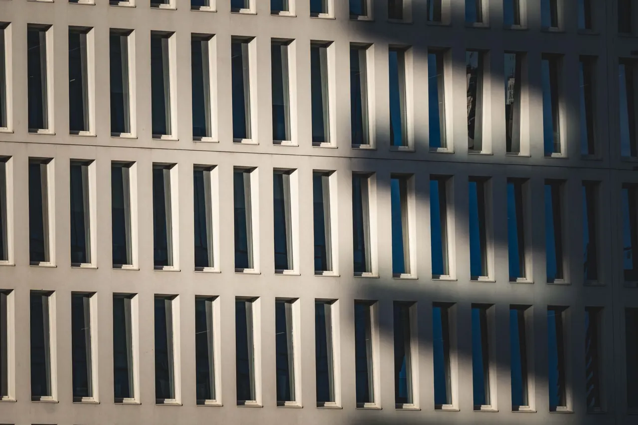 Fachada de celosía de hormigón con sombras diagonales